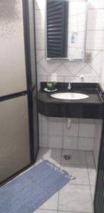 een badkamer met een wastafel en een spiegel bij Pousada NOVA Catavento in Caraguatatuba
