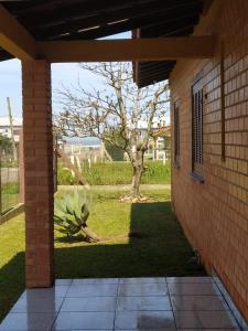 a view from the outside of a house with a palm tree at Casa Oasis in Tramandaí