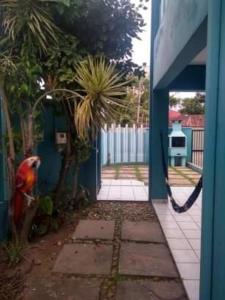 a blue door to a house with a palm tree at Pousada NOVA Catavento in Caraguatatuba