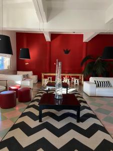 sala de estar con paredes rojas, mesa y sillas en Hotel Rex, en Piriápolis