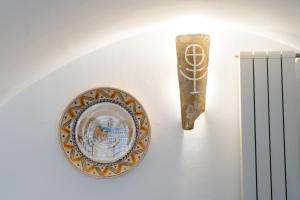 a plate and a knife hanging on a wall at Casa La Calce in Ostuni