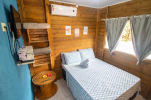 Habitación pequeña con cama y TV. en Chalés do Parque Hospedagem, en Penha