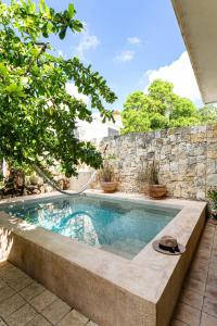 a swimming pool in front of a stone wall at Hotel Boutique Casa Hipil in Valladolid