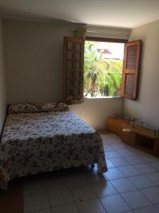 a bedroom with a bed and a large window at Linda casa Porto das Dunas: 4 suítes, churrasqueira e piscina in Fortaleza