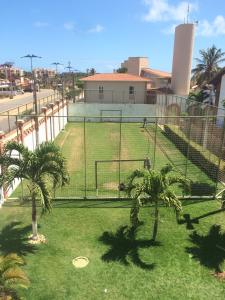 a baseball field with palm trees in front of a building at Linda casa Porto das Dunas: 4 suítes, churrasqueira e piscina in Fortaleza