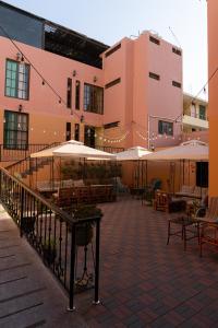 a patio area with tables, chairs and umbrellas at Desert Nights Hostel in Ica