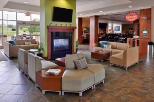 hol z kanapami i krzesłami oraz kominkiem w obiekcie Holiday Inn Madison at The American Center, an IHG Hotel w mieście Madison