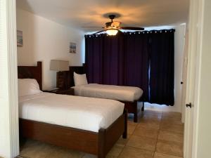 a bedroom with two beds and a ceiling fan at Palms at Wailea Condo 1802 in Wailea