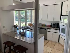 a kitchen with white cabinets and a counter top at Palms at Wailea Condo 1802 in Wailea
