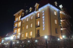 a large building with lights on it at night at Naftusya Hotel in Truskavets