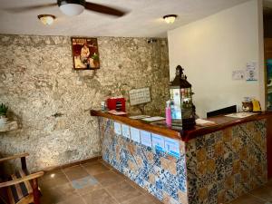 a bar in a restaurant with tiles on the wall at Yaxche Centro Hostal y Camping in Bacalar