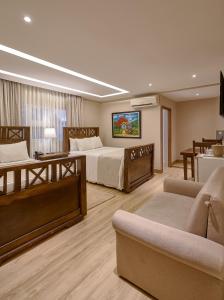 a hotel room with two beds and a couch at Hotel Riazor in Santo Domingo