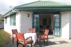 - un ensemble de chaises et d'une table sur une terrasse dans l'établissement Haven On Carroll, à Palmerston North