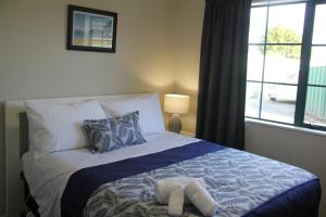 1 dormitorio con 1 cama con manta azul y blanca en Haven On Carroll, en Palmerston North