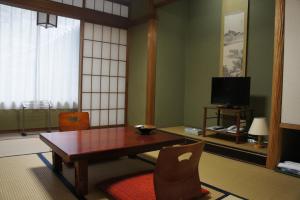 a living room with a table and a tv at Sumiyoshiya in Kanazawa