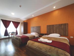 a hotel room with two beds with towels on them at Hostal NIZZA in Cuenca