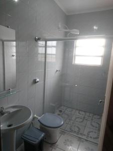 a bathroom with a shower and a toilet and a sink at Fonseca's House in Itanhaém