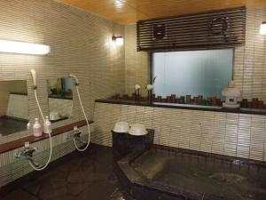 a bathroom with a tub and a shower and a sink at Sumiyoshiya in Kanazawa