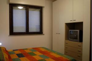 a bedroom with a bed and a tv and a window at RTA Martin Pescatore in Grosseto