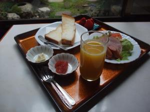 a tray with a plate of food and a glass of orange juice at Sumiyoshiya in Kanazawa