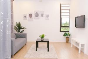 a living room with a couch and a table at Langkawi Green View Cottage in Pantai Cenang