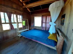 1 dormitorio con 1 cama en una habitación de madera en Homie homestay, en Loung Co