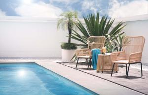 a patio with two chairs and a swimming pool at The Howard Plaza Hotel Kaohsiung in Kaohsiung