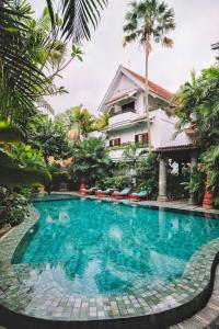 a swimming pool in front of a house at Hotel Tugu Malang - CHSE Certified in Malang
