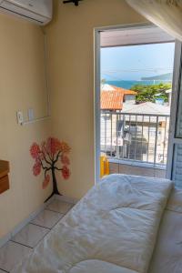 1 dormitorio con cama y vistas al océano en Residencial da Praia, en Florianópolis