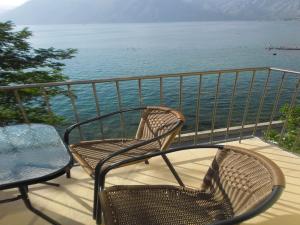 2 sillas y una mesa en un balcón con vistas al agua en Apartment Ivanišević 2, en Kotor