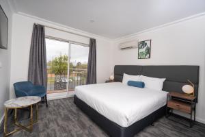 a hotel room with a bed and a window at Littomore Suites Bathurst in Bathurst