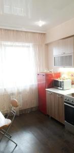 a small kitchen with a microwave and a stove at Аэропорт in Irkutsk
