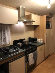 a kitchen with a stove and a refrigerator at Mablethorpe Seaside Cove With Private Hot Tub in Mablethorpe +37 photos