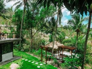 a garden with a picnic table and palm trees at Villa Kiri, Secluded Jungle Paradise in Selong Belanak