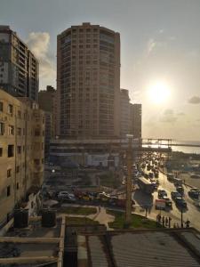 een stad met hoge gebouwen en een parkeerplaats met auto's bij Sea View Sidi Bisher - in front of Sidi Bisher Mosque - Best Choice for Families - only Families- No Solo - No unmarried please in Alexandrië