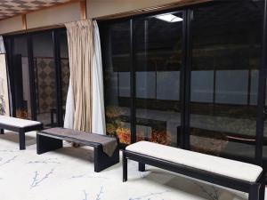 two benches sitting on a patio next to a window at Cooking inn Kagetsu - Vacation STAY 88535 in Kuradani