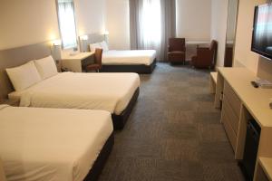 Ένα ή περισσότερα κρεβάτια σε δωμάτιο στο Strand Hotel