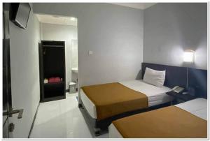 A bed or beds in a room at Losmen Family Syariah Bypass Juanda Mitra RedDoorz