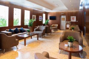 a waiting room with couches and chairs and tables at Al Rawda Arjaan by Rotana, Abu Dhabi in Abu Dhabi