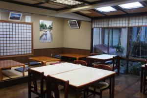 a dining room with tables and chairs and windows at Sumiyoshiya in Kanazawa
