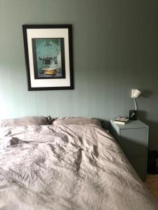 a bedroom with a bed and a picture on the wall at Aid og Svein’ s sentrumsnære panorama hjem in Kristiansand