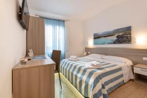 a hotel room with a bed and a desk at La Nicchia in San Vito lo Capo