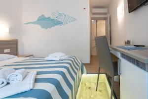 um pequeno quarto com uma cama com toalhas em La Nicchia em San Vito lo Capo