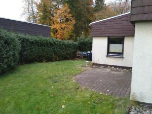 a yard next to a house with a brick driveway at Kleine Ferienwohnung, Einzimmeraparment in Altenkirchen in Almersbach