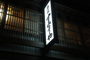 a sign on the side of a building at night at Sumiyoshiya in Kanazawa