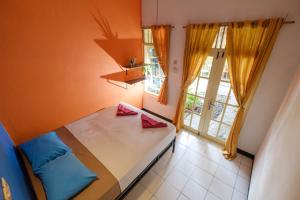 Kleines Zimmer mit einem Bett und einem Fenster in der Unterkunft ViaVia Guesthouse in Yogyakarta