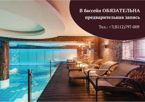 a hotel room with a pool and chairs at Dvor Podznoeva Glavniy Korpus in Pskov