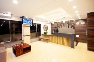 a man standing at a bar in a lobby at ABM Boutique Hotel by Purple Cloud in Bangalore