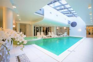 a large swimming pool with a large mirror at Wellton Centrum Hotel & SPA in Riga