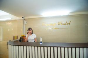 a woman talking on a cell phone behind a counter at LUXURY HOSTEL in Ha Giang